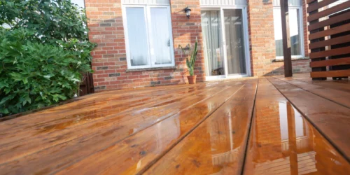 close up shot of wooden deck floor boards with fresh brown stain